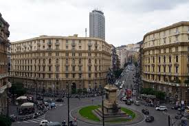 Piazza trafficata in città con edifici storici.
