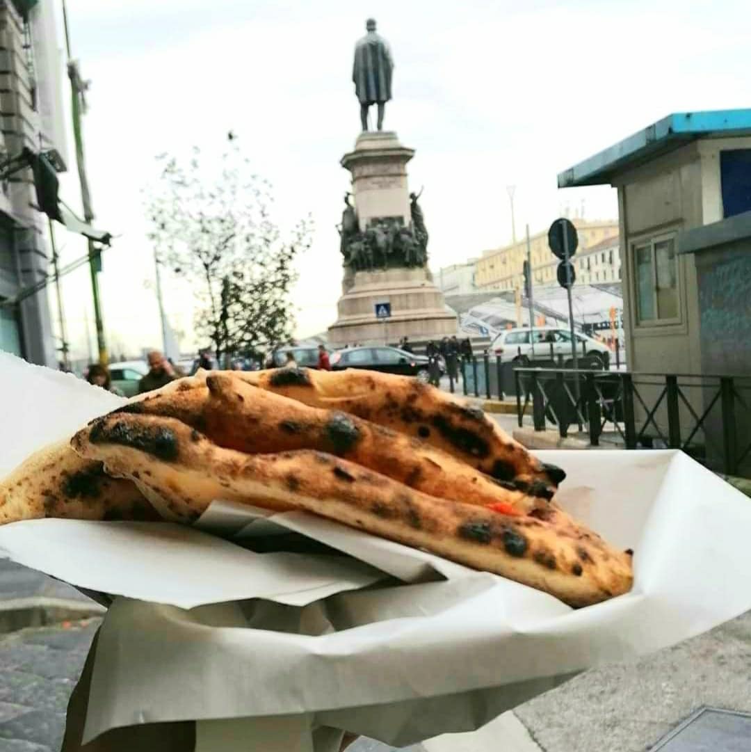 Trancio di pizza a portafoglio davanti a alla pizzeria fortuna a napolo