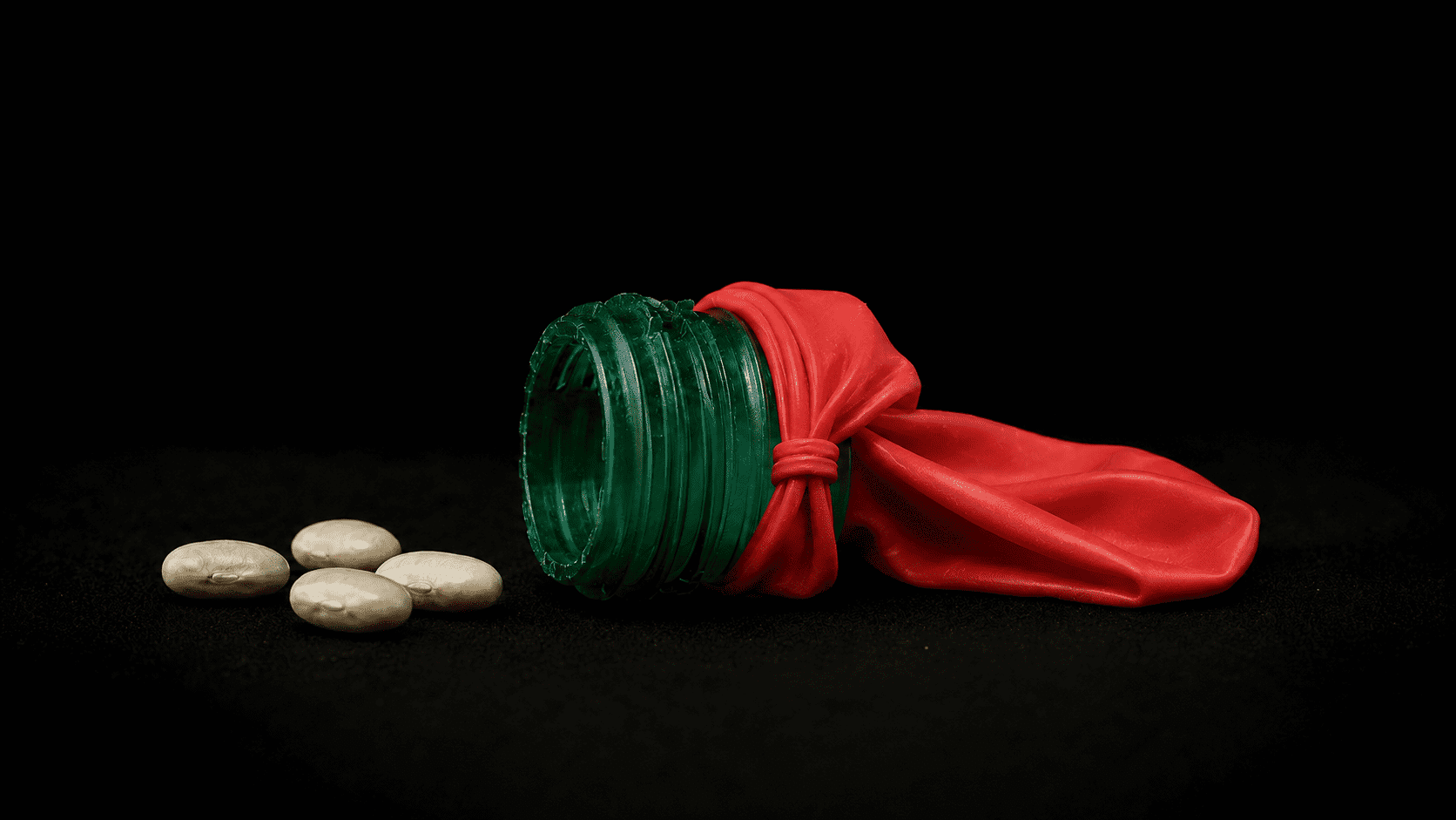 Bottiglia verde con palloncino rosso e pillole